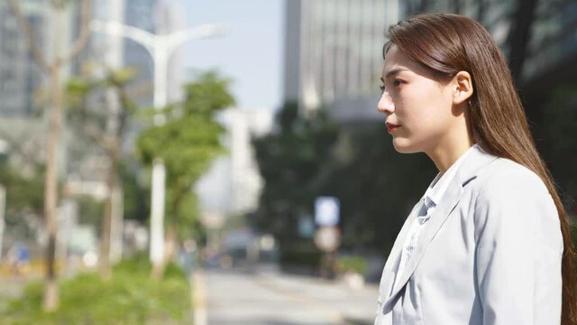 young asian business woman office worker walking crossing street in downtown of modern city
