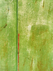 texture of old painted rusty green wall or garage door with peeling and cracked paint and corrosion