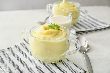 Pots with tasty mashed potatoes on table