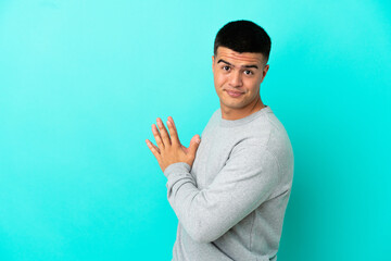 Young handsome man over isolated blue background scheming something