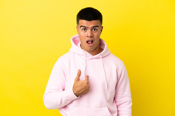 Young handsome man over isolated yellow background pointing to oneself