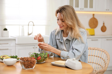 Woman with different healthy products at wooden table in kitchen. Keto diet