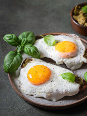 Croque-madame with fried egg , pesto sauce and basil. Traditional French Toasted Sandwich. French cuisine.