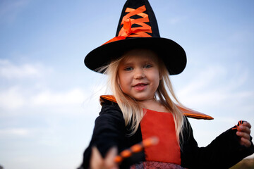 little cute girl dressed as a witch celebrates halloween