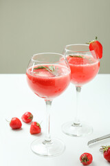 Glasses with Rossini cocktail on white table