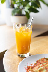 A glass of fresh orange and sea buckthorn sugar free lemonade for the breakfast close up. Summer refreshing beverage concept	