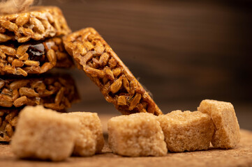 Homemade cookies with sunflower seeds and raisins tied with string and pieces of brown cane sugar on a wooden table. Close-up Selective focus.