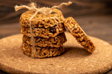 Homemade cookies with sunflower seeds and raisins tied with string on a wooden table. Close-up Selective focus.