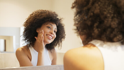Girl checking her skin in the mirror, skincare