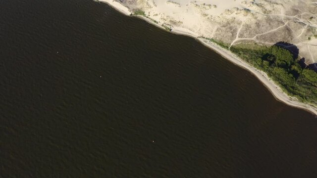 Aerial footage of water and dunes in Curonian Spit on Summer day. Lithuania