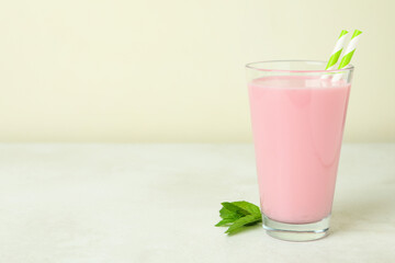 Glass of strawberry milkshake on white textured table