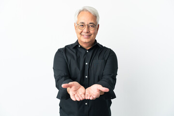 Middle age Brazilian man isolated on white background holding copyspace imaginary on the palm to...