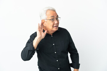 Middle age Brazilian man isolated on white background listening to something by putting hand on the ear