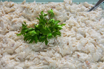 Prepairing Celery salad. Celery salad with yogurt garnished with parsley, capia pepper, lemon and pickled gherkins