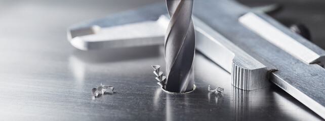 metal drill bit make holes in steel billet on industrial drilling machine. Metal work industry....