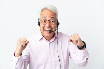 Telemarketer Middle age man working with a headset isolated on white background celebrating a victory in winner position