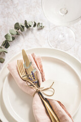 Table setting details with lavender and eucaliptus on white plates.