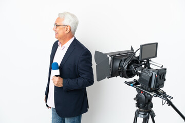 Reporter Middle age Brazilian man holding a microphone and reporting news isolated on white background laughing in lateral position