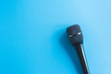 Microphone on a colorful blue background close up. Singing, writing music, karaoke online, creativity, vocals concept, symbol. Singing lessons