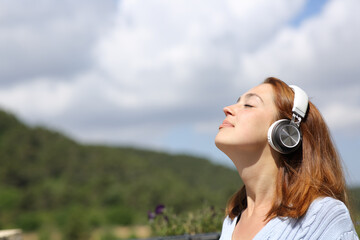 Woman meditating listening audio guide on headphones