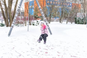 child walks in the park in winter. baby bungee rides in the snow