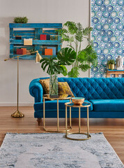 Blue classic sofa furniture home design, gold lamp and middle table, wooden palette bookshelf, vase of green plant and home accessory style,interior decor.