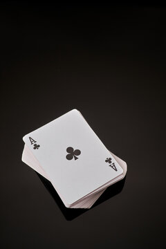 Full deck of playing cards with ace on top on dark reflective background