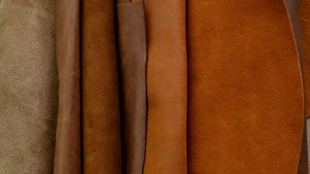 Genuine leather in warm brown tones. Rolls of genuine leather. Fabric texture. Genuine leather surface