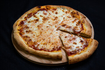 Pizza with tomato sauce and mozzarella cheese on a black background.