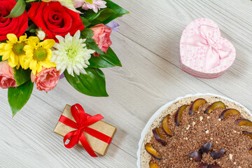 Naklejka na ściany i meble Chocolate cake decorated with plums and flowers