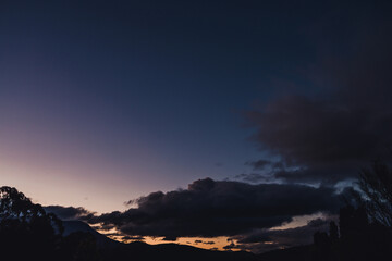 winter sunset with intense colours over the mountains and thick vegetation shot in Tasmania