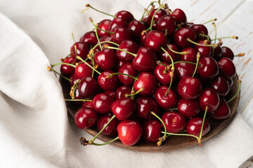 Wooden Bowl of organic Cherries on white table