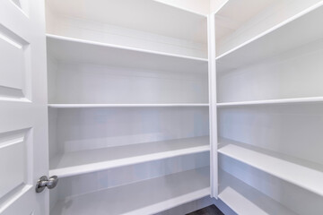 Empty pantry of house with built in shelves for storage and organization of food