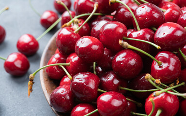 Sweet ripe cherries in wooden bowl on a table Beautiful juicy berries on the dark background