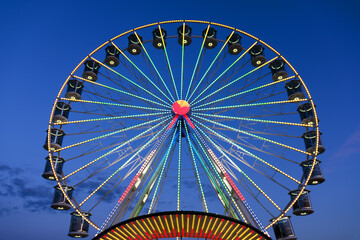 High Ferris Wheel against dark night sky in our summer vacation at Adriatic seaside. Amusement park ride. Holidays concept.