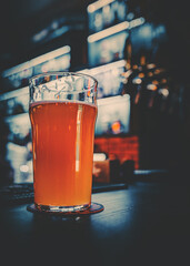 glass of light beer stands on bar counter in a bar or pub
