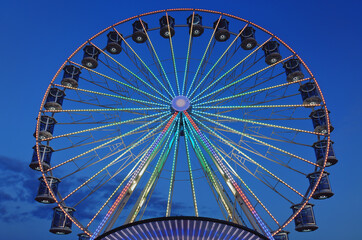 High Ferris Wheel against dark night sky in our summer vacation at Adriatic seaside. Amusement park ride. Holidays concept.
