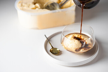.Black coffee pouring into the glass cup with vanilla ice cream. Affogato italiano de café.
