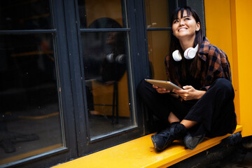 Fototapeta na wymiar Urban happy woman using digital tablet. Beautiful young woman having video call outdoors