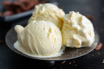 Vanilla ice cream scoops on dark plate
