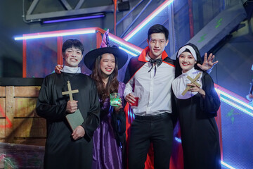 Group of young Asian friends dressed as witch, priest, vampire and nun makeup face with blood and...