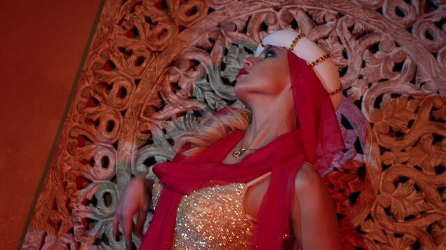 sexy concubine in harem of sultan, blonde woman is dancing oriental dance