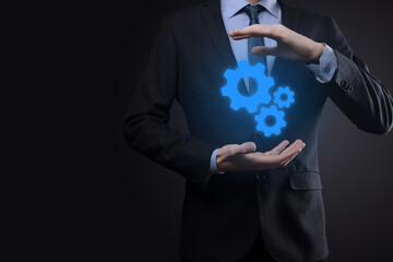 Business man in suit holding metal gears and cogwheels mechanism representing interaction teamwork concept,hand hold group of virtual cog gears wheel