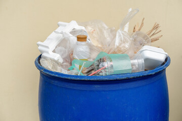Close up of overflowing garbage bins with household waste in city. Blue bins to conserve the...