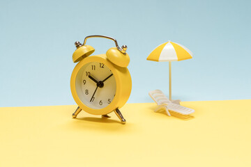 Time to travel. Sun lounger, yellow umbrella and alarm clock.
