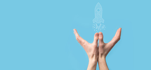 Male hand holding digital transparent rocket icon.Startup business concept. Rocket is launching and...
