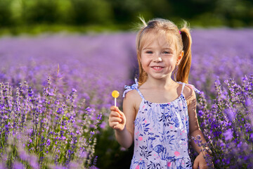 Little girl with lollipop in lavender garden