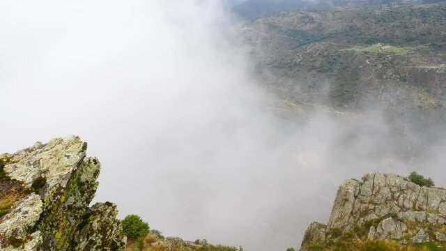 Mountain and Douro river with spanish Saucelle Dam at foggy cloudy weather. Border between Portugal and Spain. National Parks. View from portuguese Penedo Durao lookout.