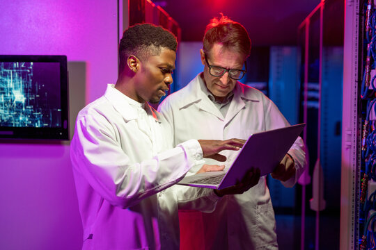 Multi-ethnic IT Engineers Analyzing Data on Laptop