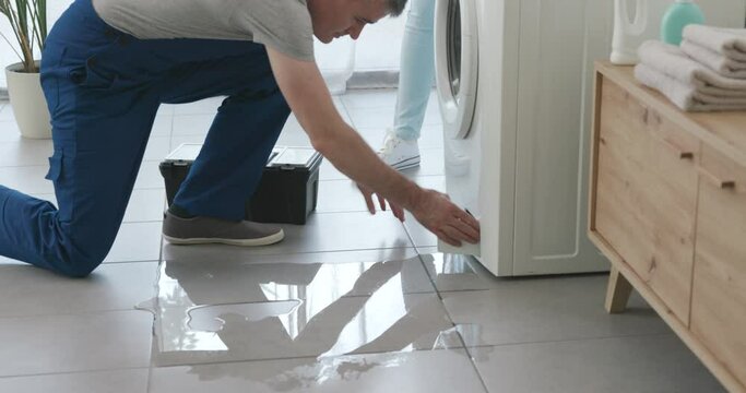 Plumber checking a leaking washing machine